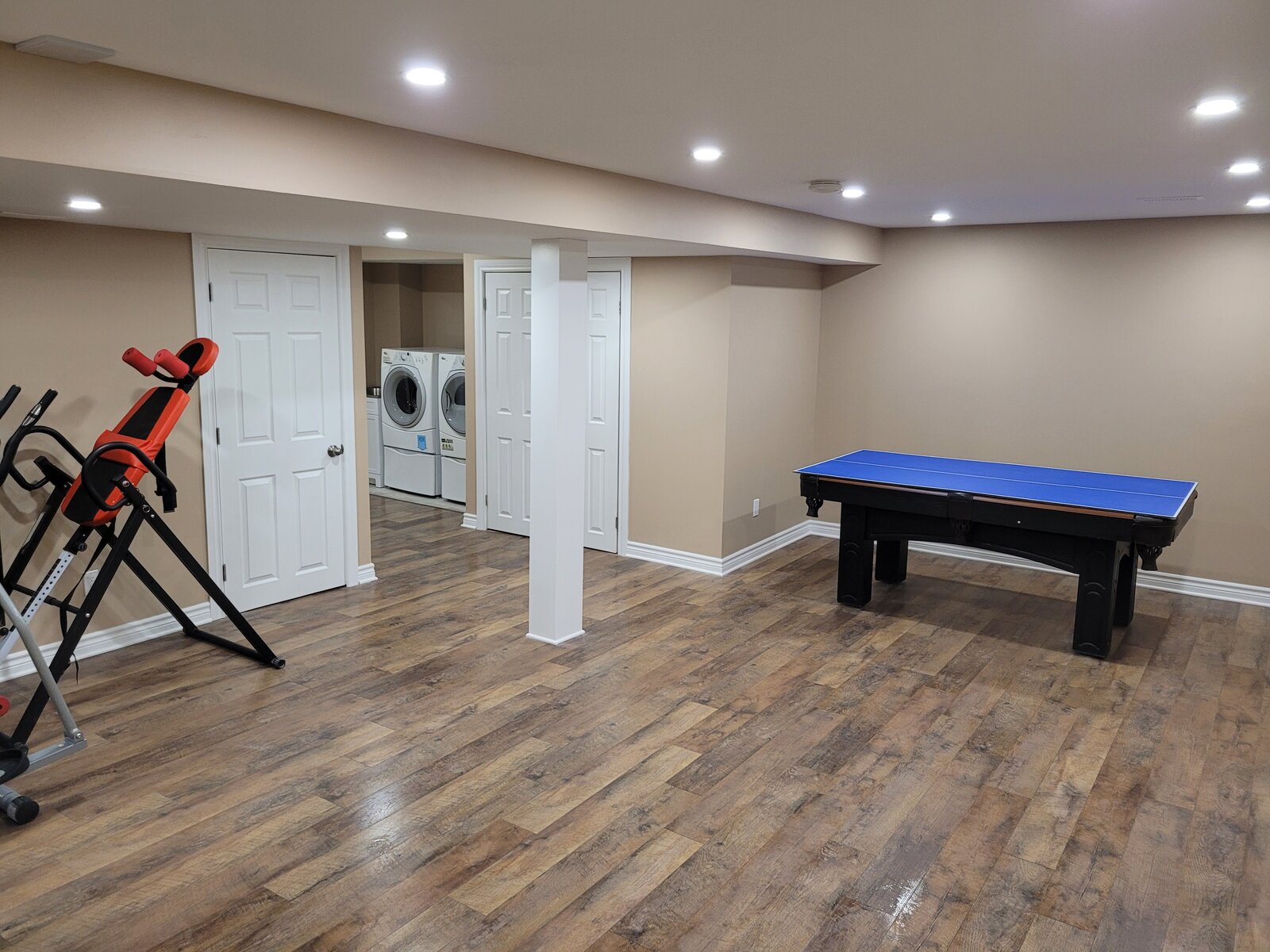 Finished basement recreation room with wood flooring