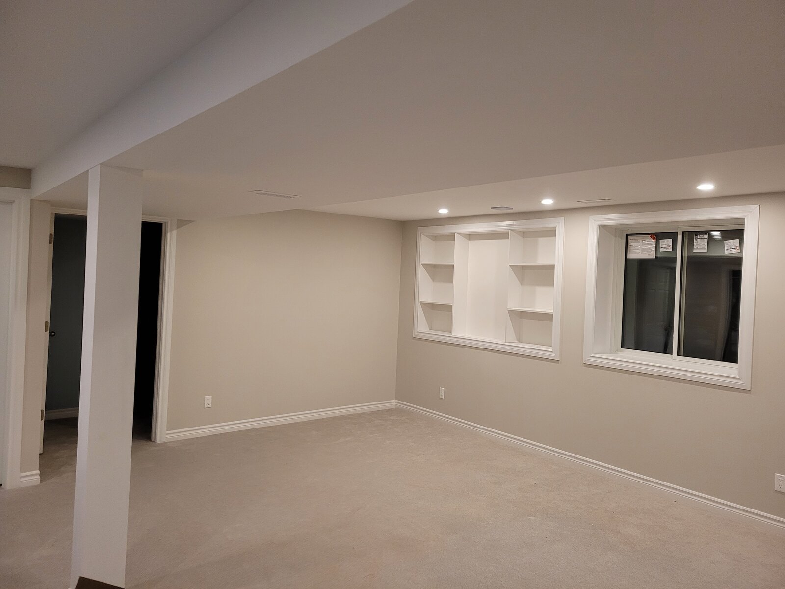 Finished basement living area with recessed lighting and trim
